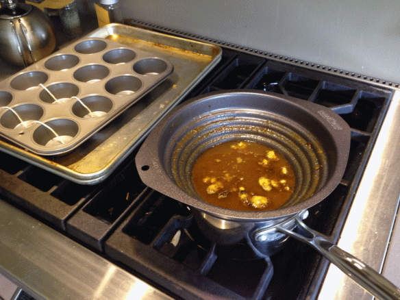 Bees wax melts in the double boiler, muffin pan stands by. I was going to embed twine in the mold to help release the dried wax muffins, but decided I probably wouldn't need to do that. I was correct.